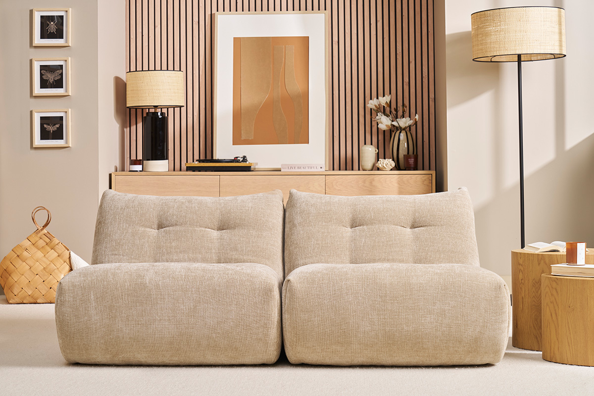 Soggiorno con due poltrone lounge BUMPY in velluto taupe davanti a un mobile in legno.