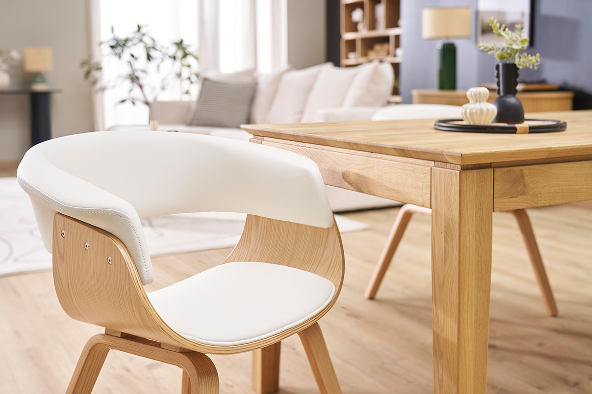 Sedia scandinava bianca e legno chiaro OKTAV vista di profilo accanto a un tavolo in legno.