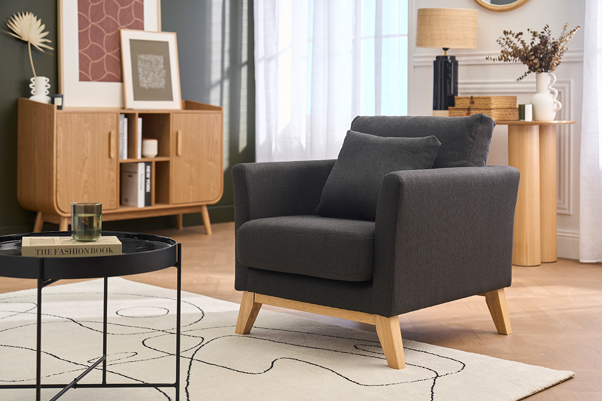 Poltrona scandinava grigio scuro e legno chiaro OSLO, vista da tre quarti in un soggiorno.