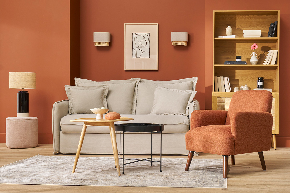 Soggiorno con divano, poltrona in tessuto arancione, tavolino in legno e scaffale.
