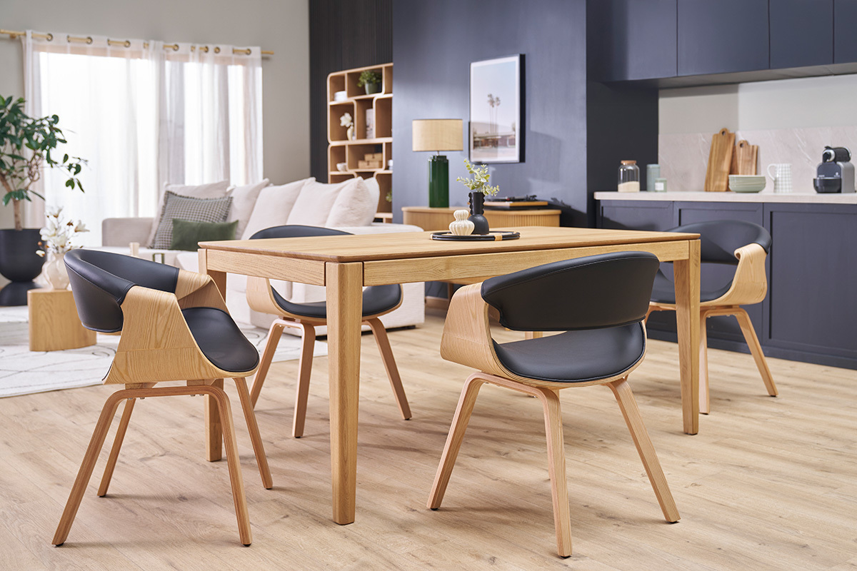 Sedie ARAMIS nere e in legno chiaro intorno a un tavolo da pranzo in un soggiorno moderno.