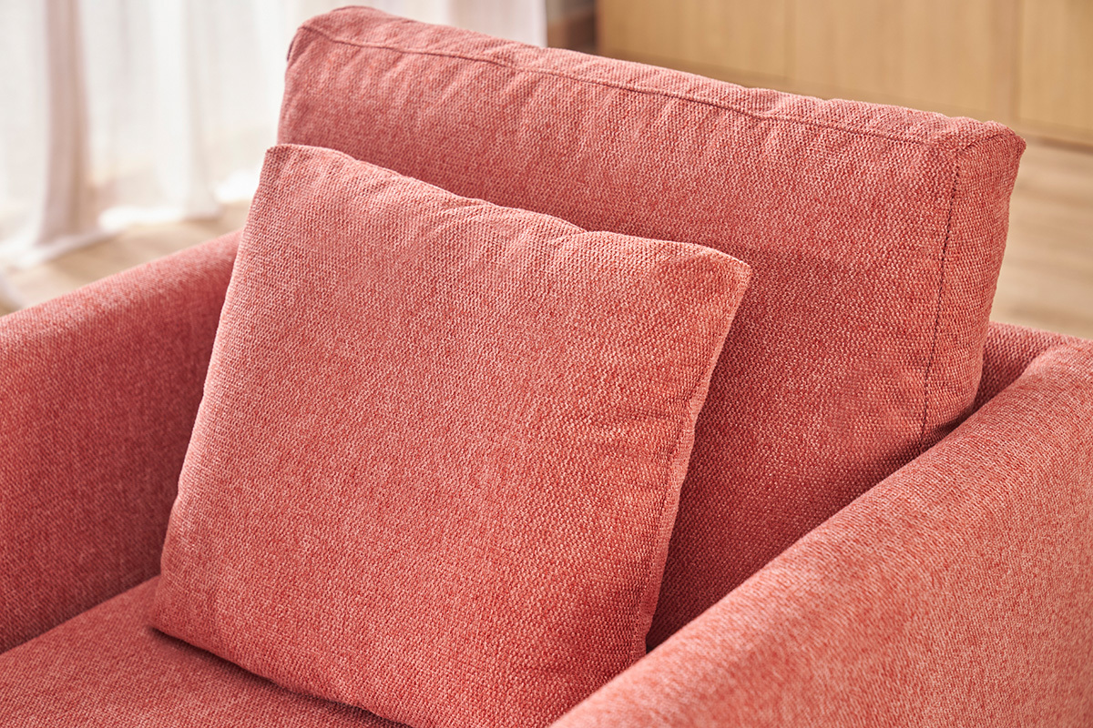Primo piano sullo schienale e sul cuscino della poltrona scandinava terracotta in tessuto effetto velluto.