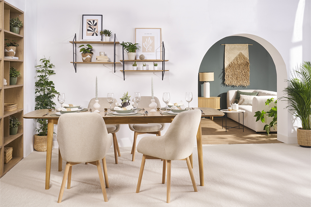 Sala da pranzo con sedie scandinave beige in tessuto e gambe in legno chiaro intorno a un tavolo.