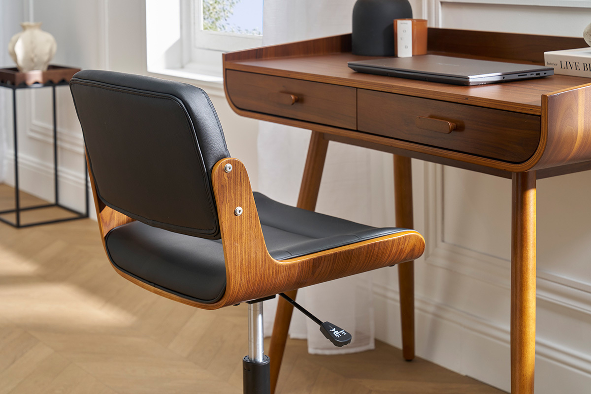 Sedia da ufficio ARAMON in nero e legno, vista laterale accanto a una scrivania in legno scuro.