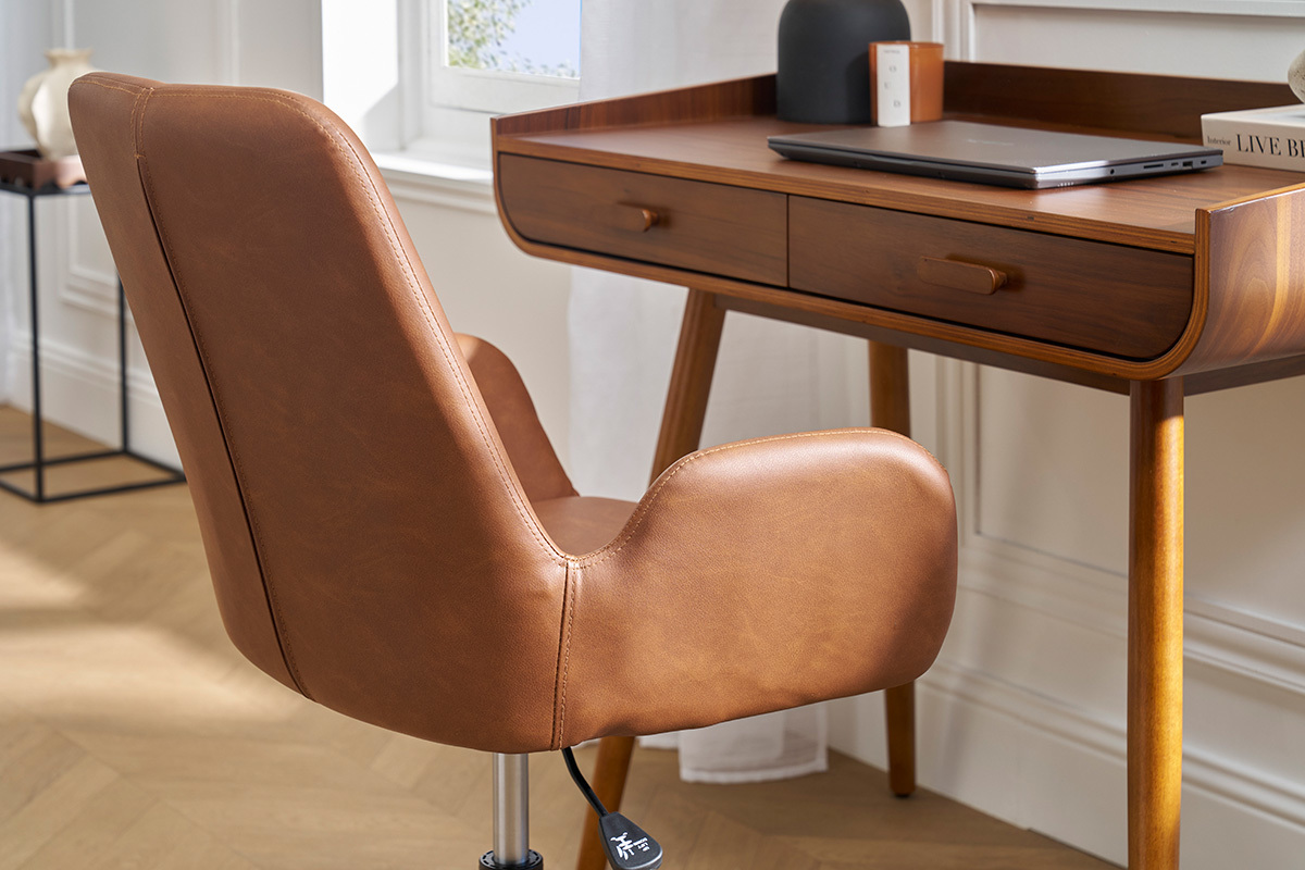 Sedia da ufficio marrone con ruote vista di lato davanti a una scrivania in legno.