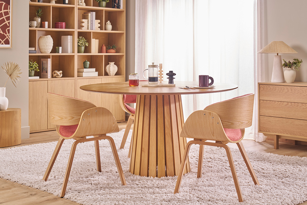 Sedia di design BENT in tessuto e legno chiaro, vista d'insieme attorno a un tavolo in legno.