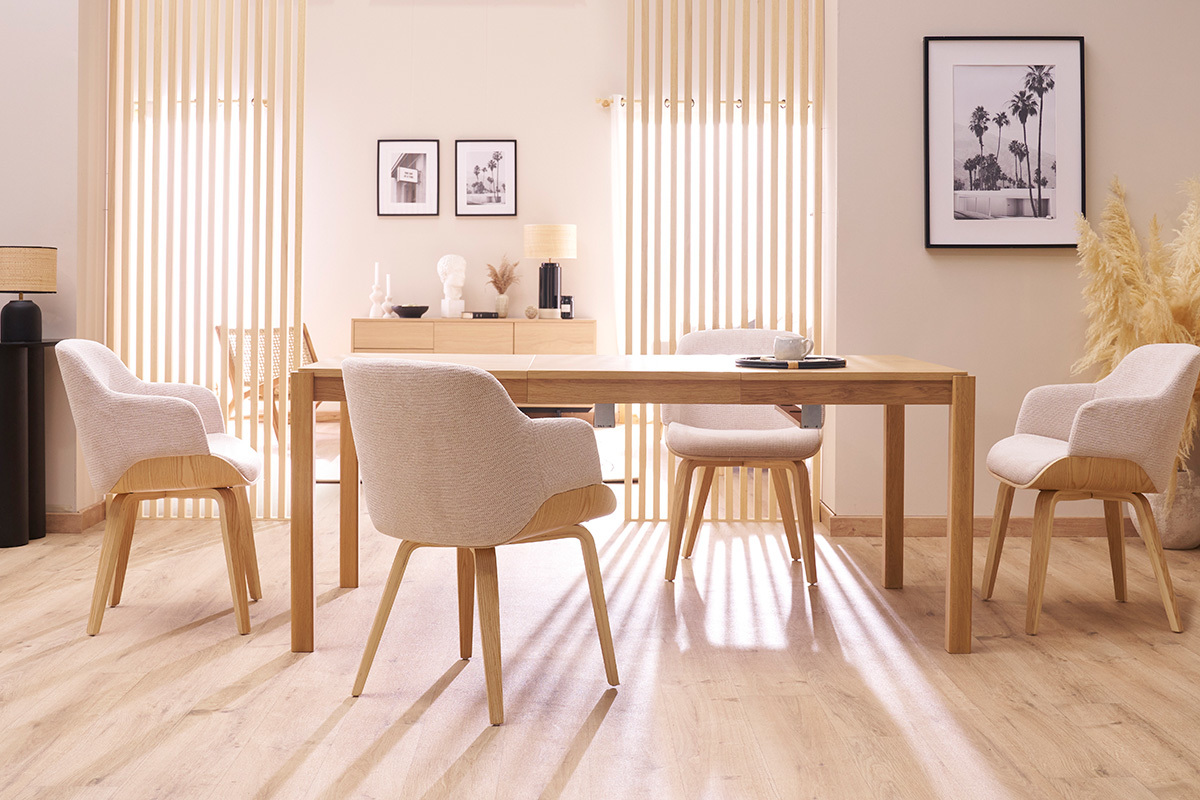 Sala da pranzo con quattro sedie EARL in tessuto di ciniglia grigio e gambe in legno chiaro intorno a un tavolo di legno.