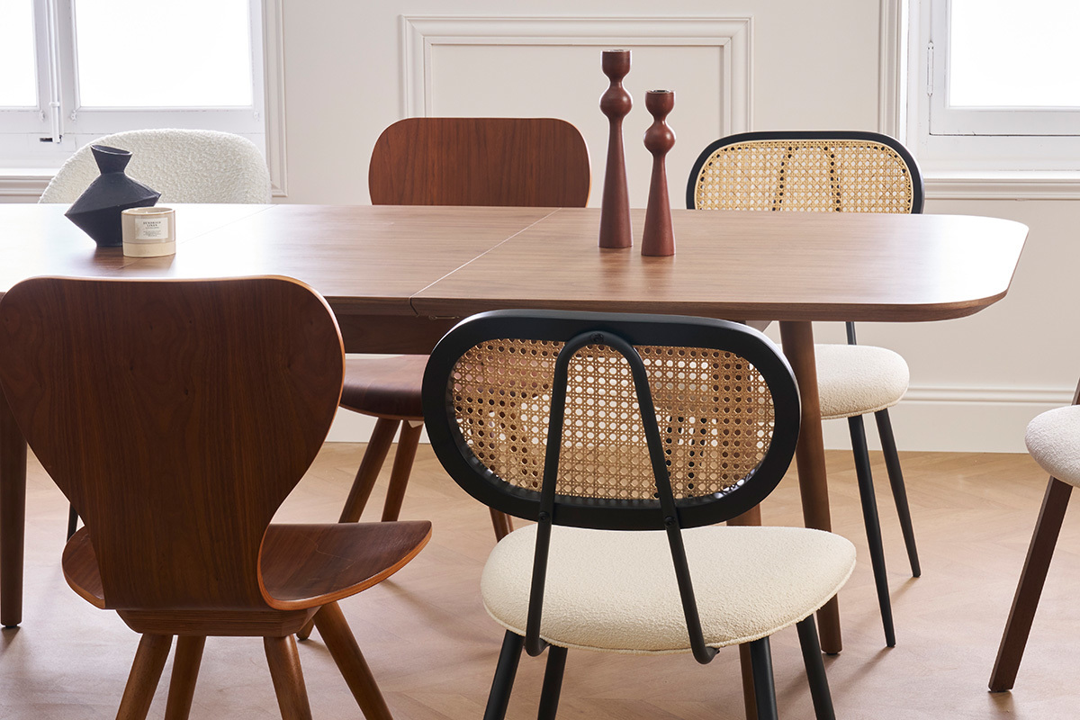 Sedie SWANN in tessuto bianco e rattan intorno a un tavolo in legno.