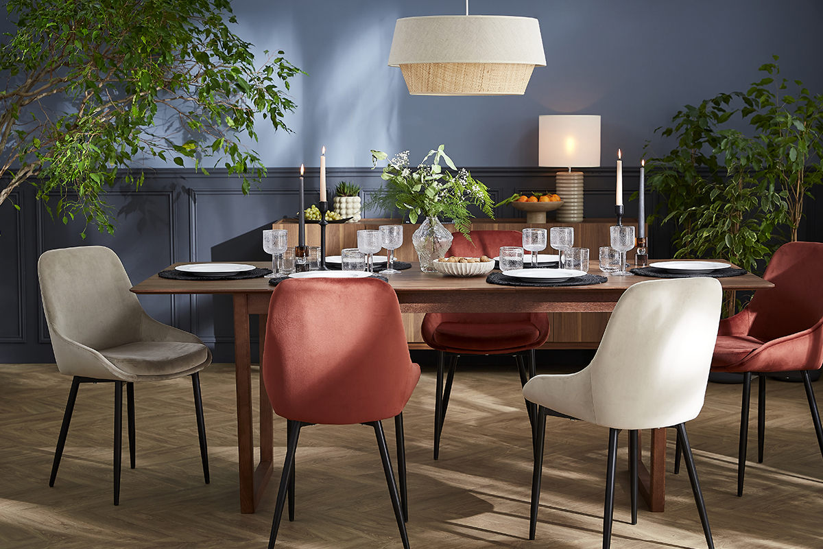 Sedie di design colorate, presentate attorno a un tavolo da pranzo.