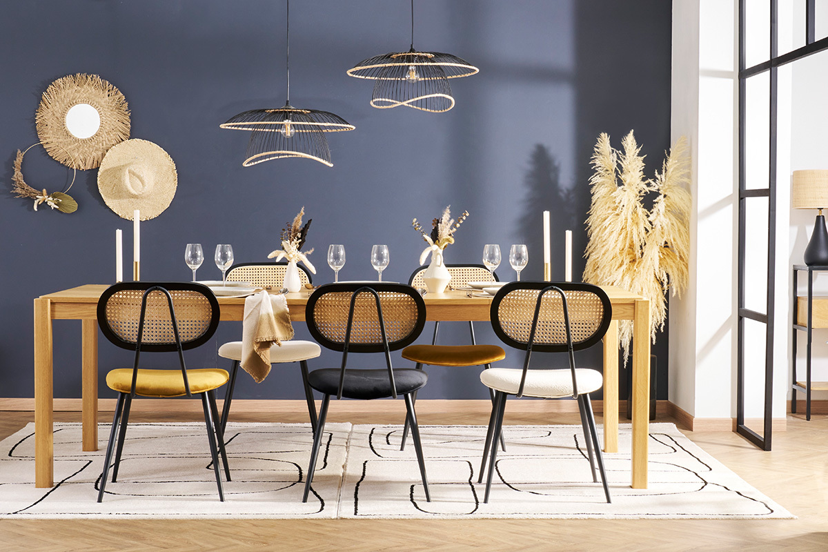 Sala da pranzo con sedie SWANN in velluto e canna intorno a un tavolo in legno.