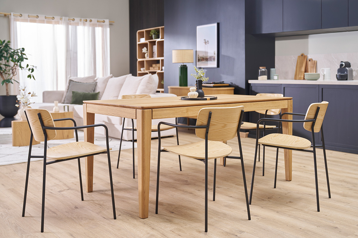 Sedie in legno chiaro e metallo nero intorno a un tavolo in legno in un interno moderno.