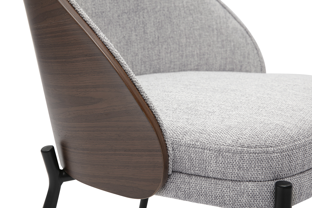 Dettaglio di una sedia con rivestimento grigio testurato, legno scuro e gambe in metallo nero.