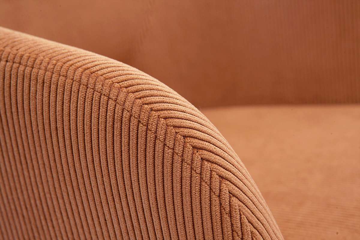 Primo piano su tessuto in velluto a coste color terra bruciata di una sedia.