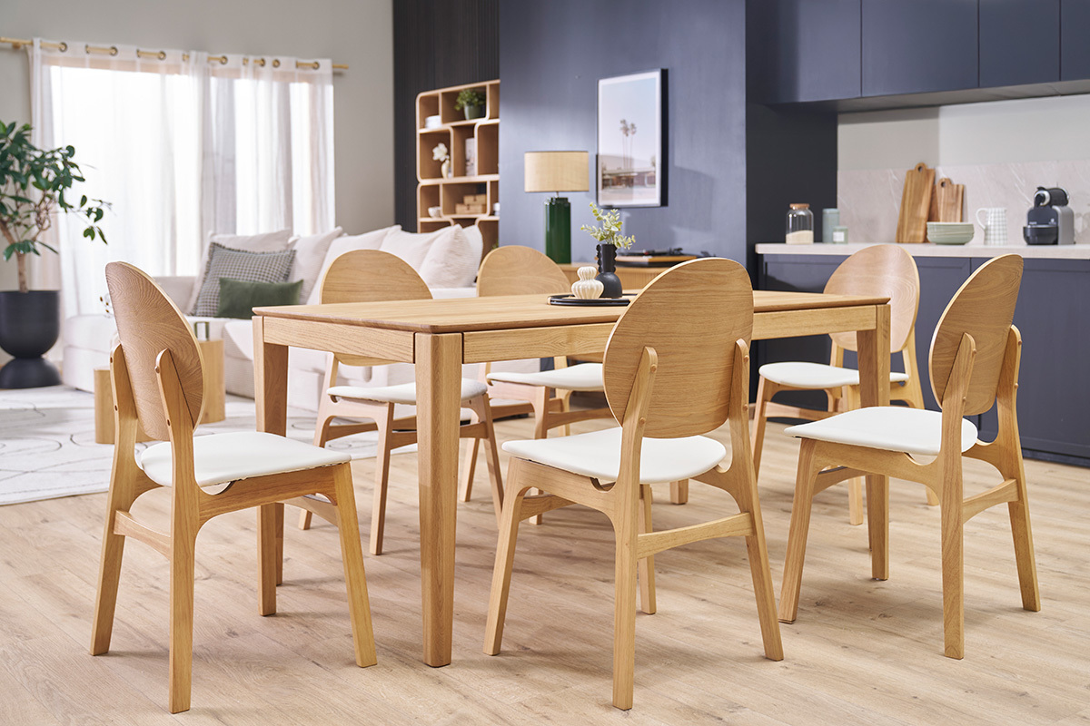 Sedie scandinave in legno chiaro e bianco intorno a un tavolo, in una sala da pranzo moderna.