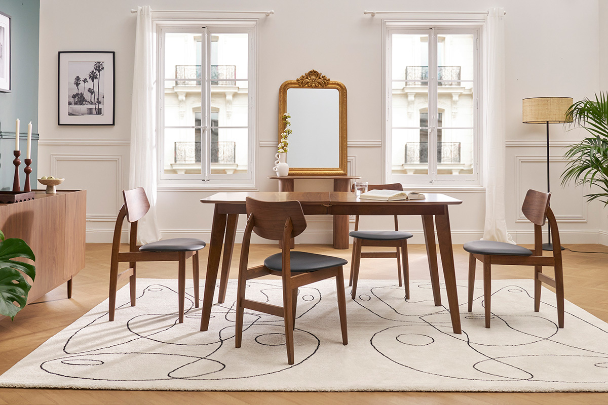 Sala da pranzo con sedie in legno scuro e tessuto verde intorno a un tavolo su un tappeto.