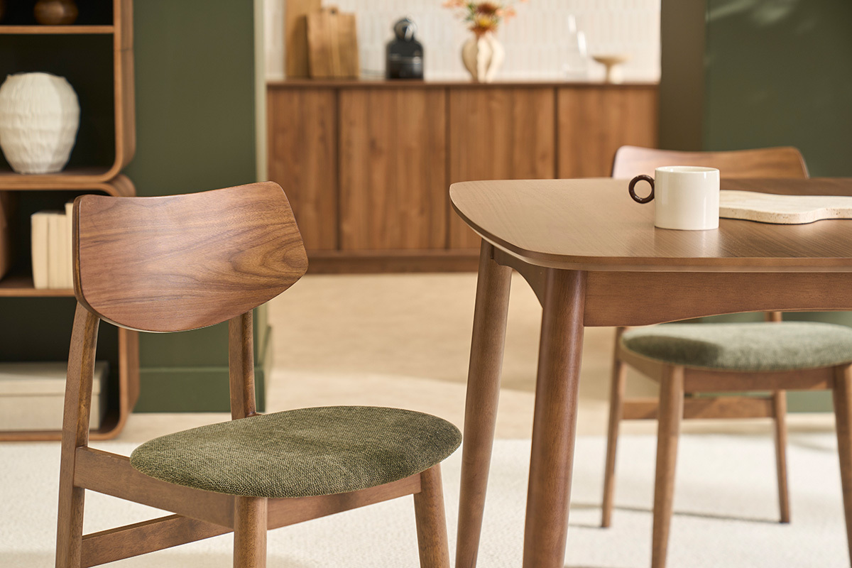 Sedie scandinave in legno scuro e tessuto verde kaki, vista ravvicinata su una sedia accogliente.