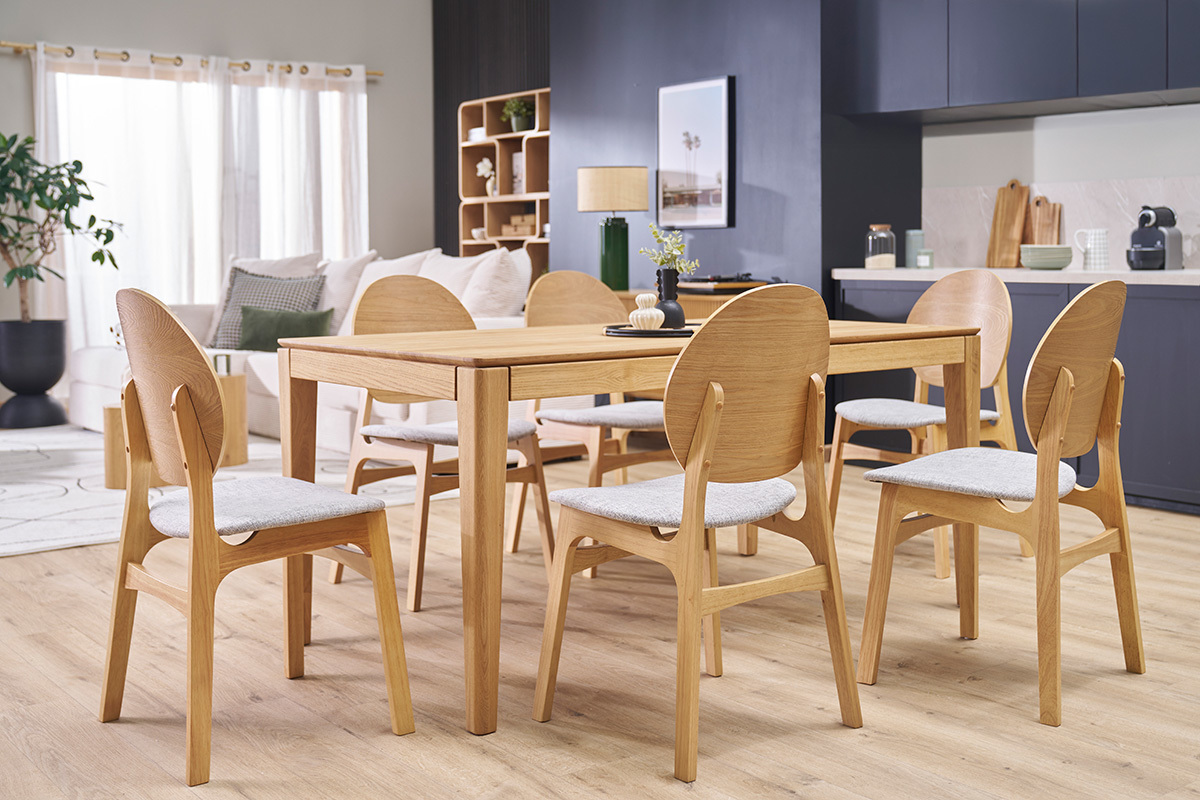 Sedie scandinave ELTON in legno chiaro e tessuto grigio chiaro intorno a un tavolo da pranzo, vista a 3/4