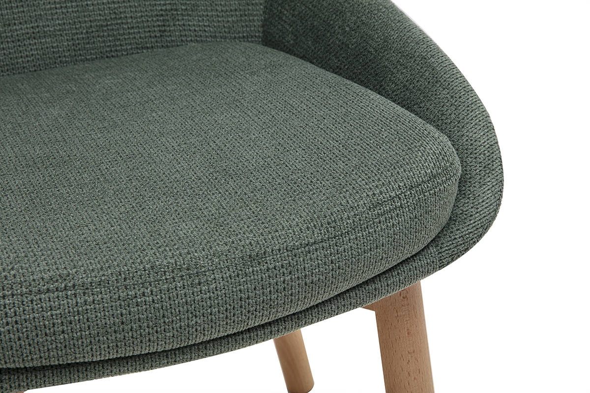 Dettaglio della seduta di una sedia scandinava in tessuto chenille verde kaki con gambe in legno chiaro.