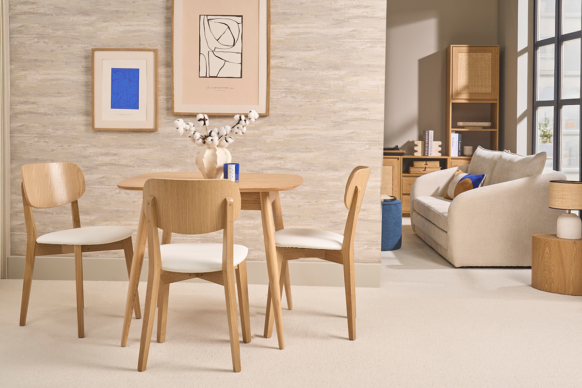 Sedie vintage LUCIA in legno chiaro e seduta bianca, davanti a un tavolo in un arredamento scandinavo.