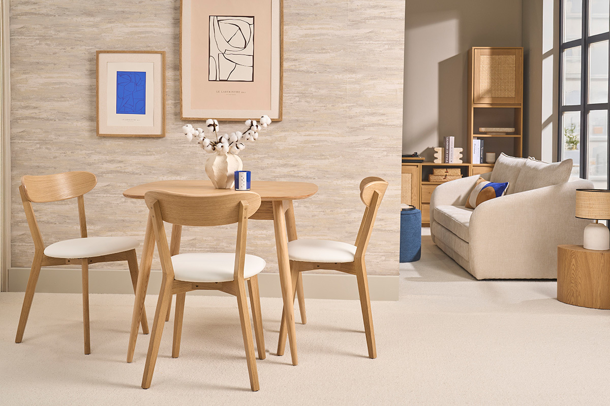 Sedie vintage in legno chiaro di rovere e bianco, stile bistrot, vista su un tavolo rotondo.