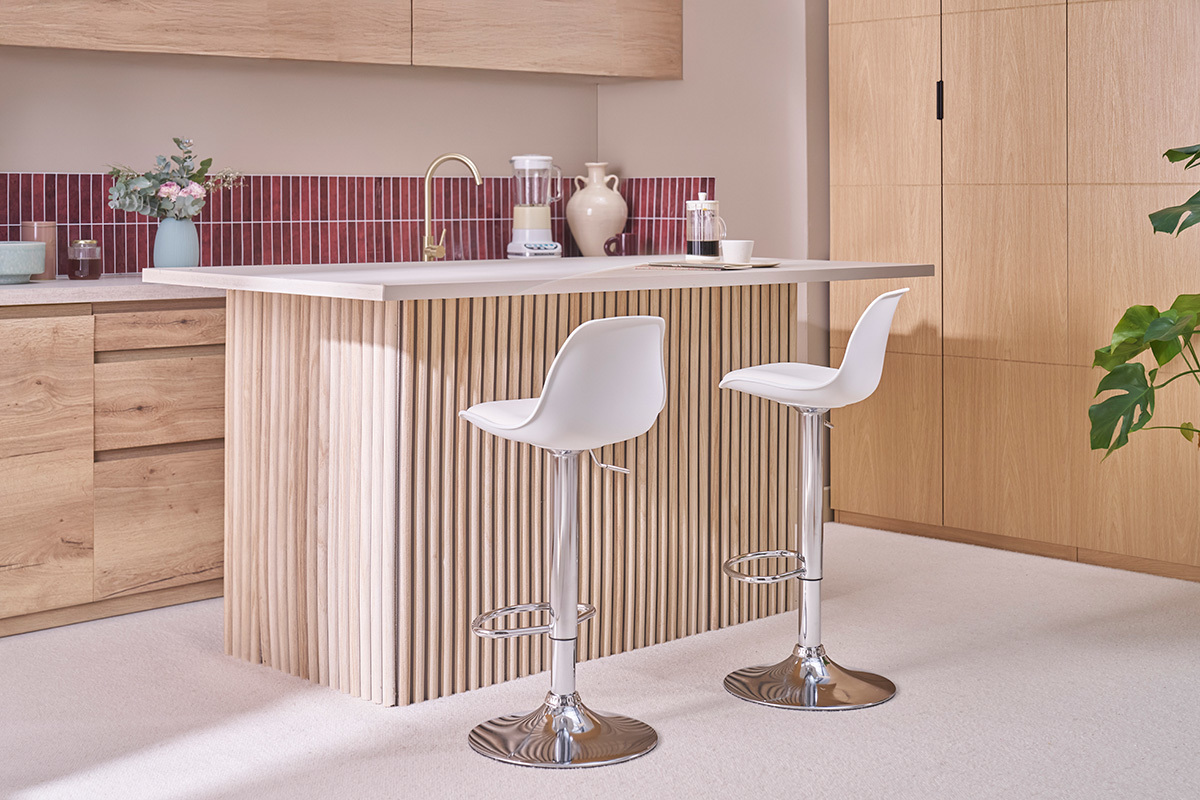 Sgabelli da bar bianchi con piede cromato, vista laterale in una cucina moderna.