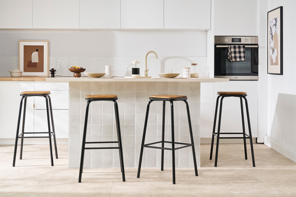 Sgabelli MEMPHIS neri e in legno scuro davanti ad un'isola da cucina.