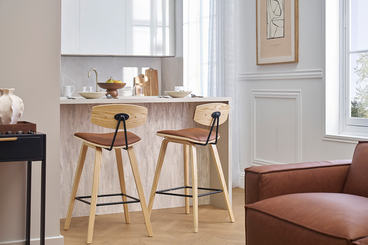 Due sgabelli da bar marroni e in legno chiaro di fronte a un bancone in una cucina moderna.