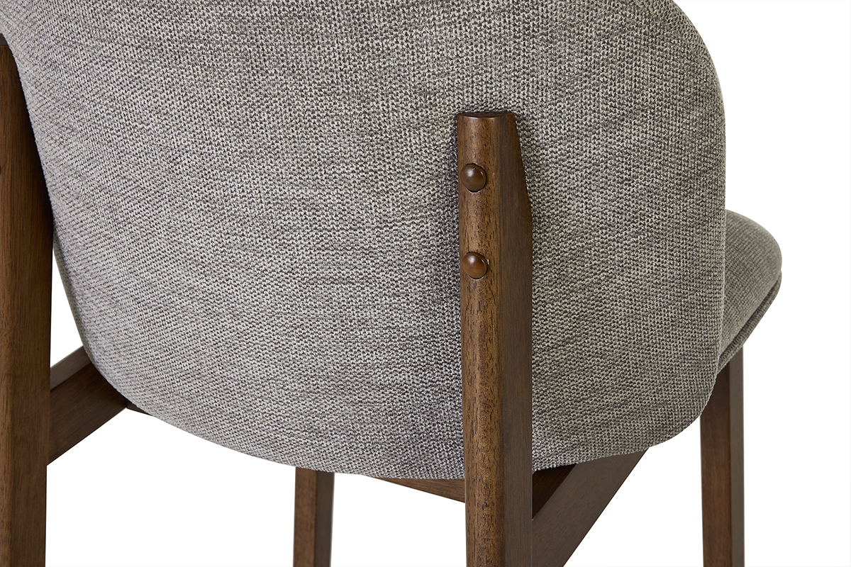 Dettaglio della struttura di uno sgabello in tessuto grigio e legno scuro.