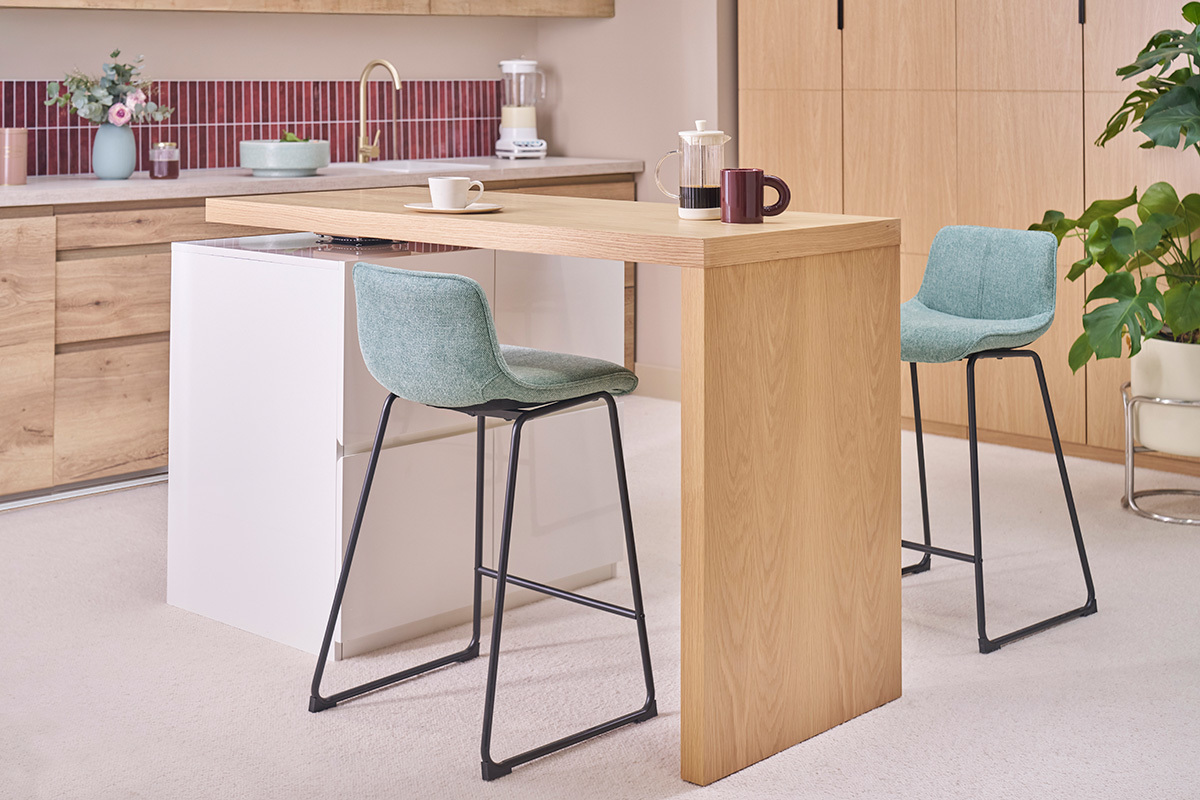 Sgabelli da bar in tessuto blu-verde con gambe in metallo nero, in una cucina moderna.