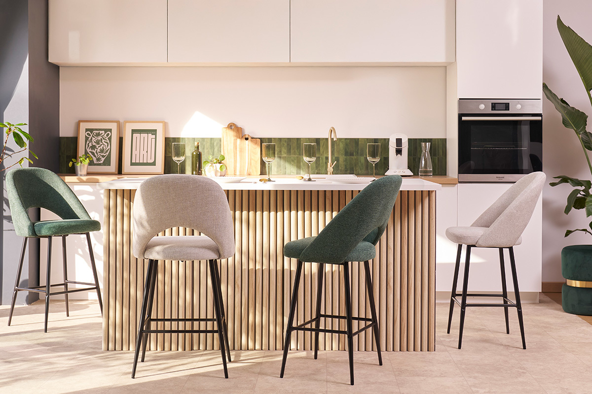 Sgabelli da bar colorati attorno a un'isola da cucina.