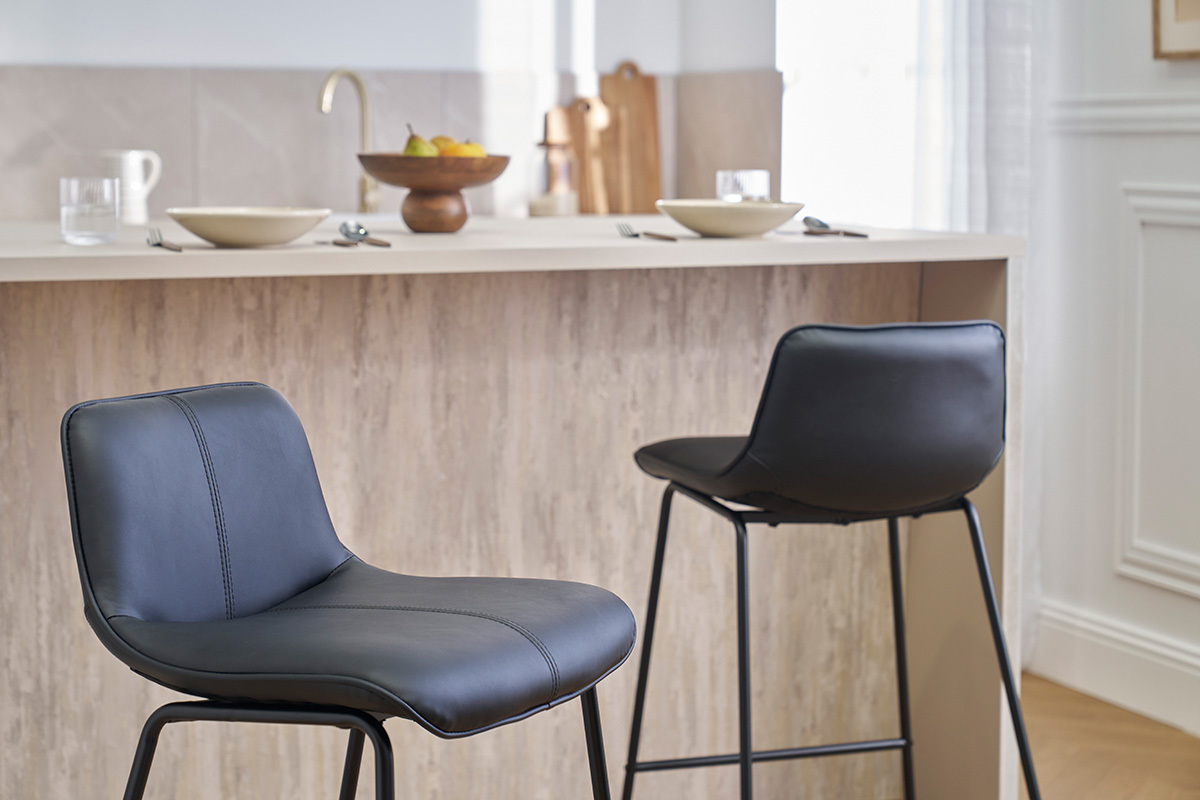 Due sgabelli da bar neri in metallo davanti a un bancone da cucina.
