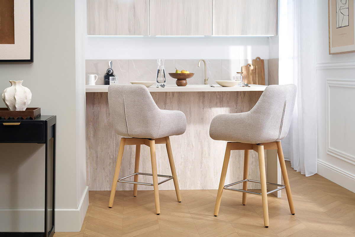 Due sgabelli da bar scandinavi beige davanti a un bancone da cucina.
