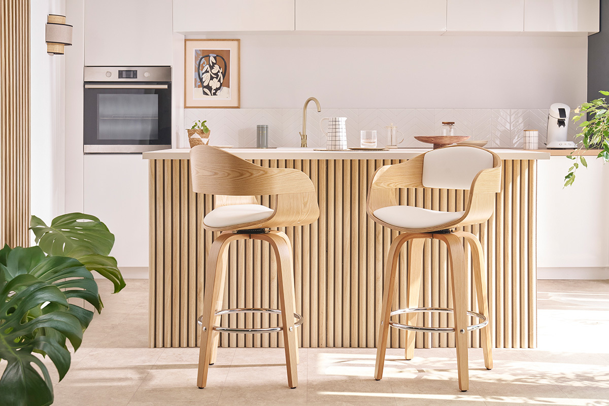 Due sgabelli da bar scandinavi in legno chiaro davanti a un bancone da cucina.