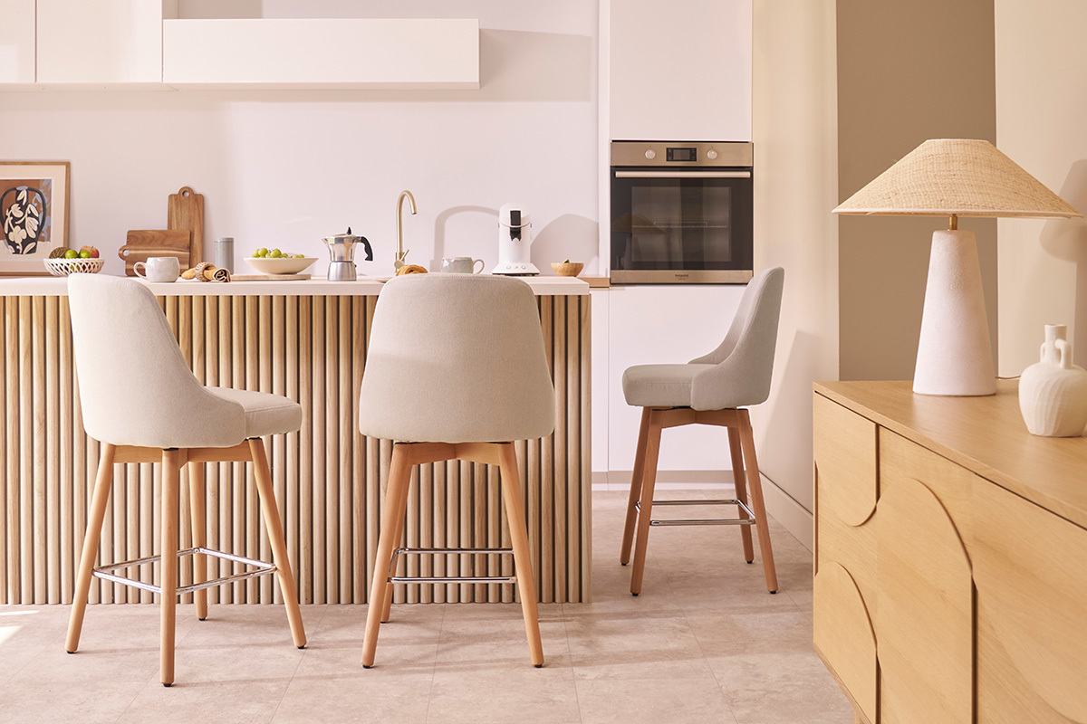Sgabelli da bar scandinavi girevoli in tessuto beige, in una cucina moderna.