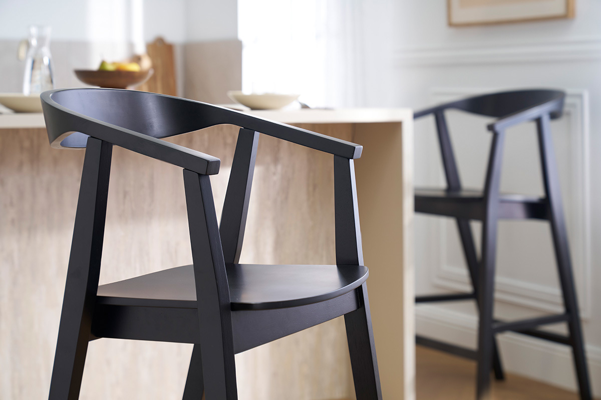 Due sgabelli da bar neri in legno BAHIA vicino a un bancone, vista ravvicinata.