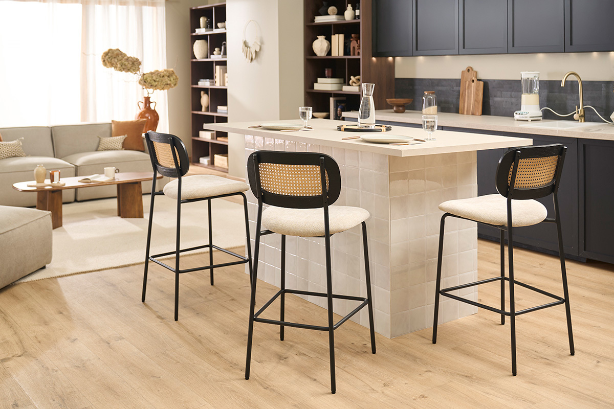 Tabourets design MIRANDA in tessuto velluto beige e metallo nero al bancone di una cucina moderna.