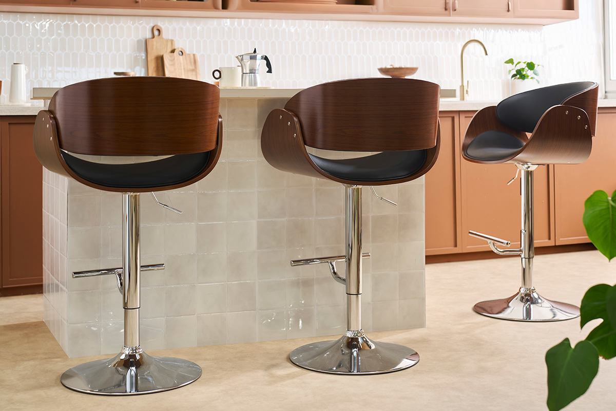 Sgabello da bar di design regolabile nero e legno scuro BENT, vista in tre quarti in una cucina