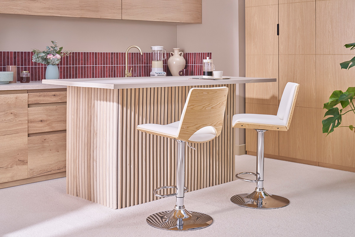 Sgabelli da bar regolabili bianchi e in legno chiaro PANACH in una cucina moderna con isola centrale.