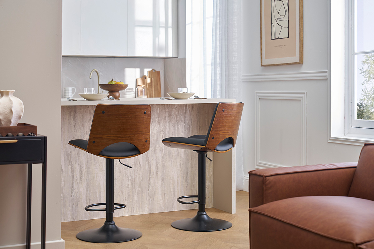 Due sgabelli da bar PANACH in legno scuro e nero, davanti a un'isola da cucina.