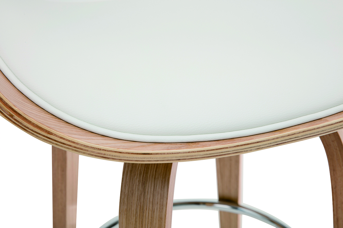 Dettaglio dello sgabello BENT, seduta bianca e gambe in legno.