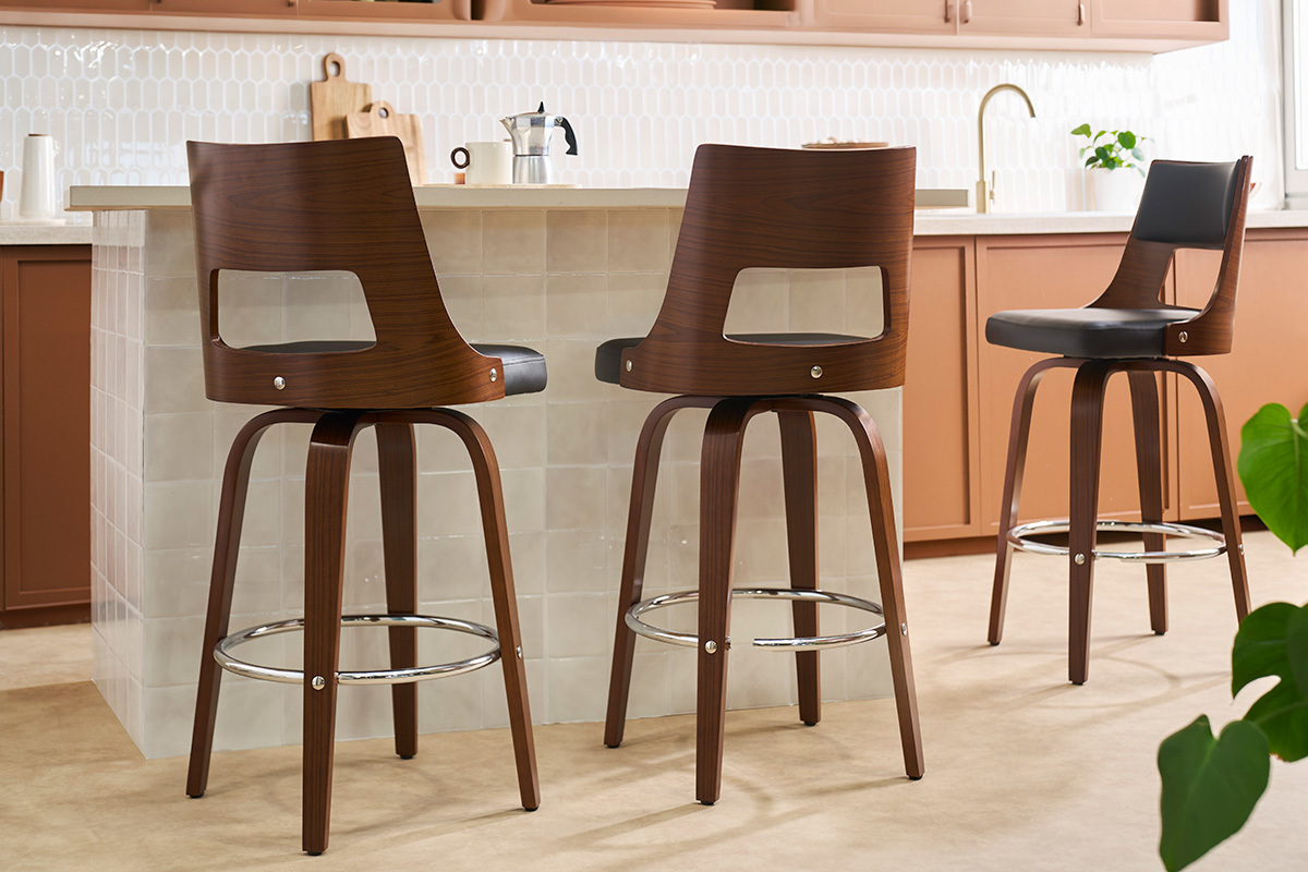 sgabello da bar vintage girevole nero e legno scuro visto di spalle in una cucina moderna