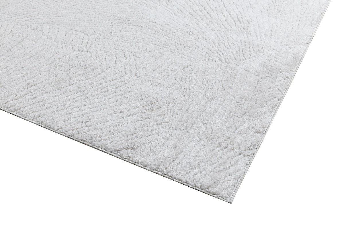Tappeto rettangolare avorio con motivi, vista dettagliata con texture sul bordo.