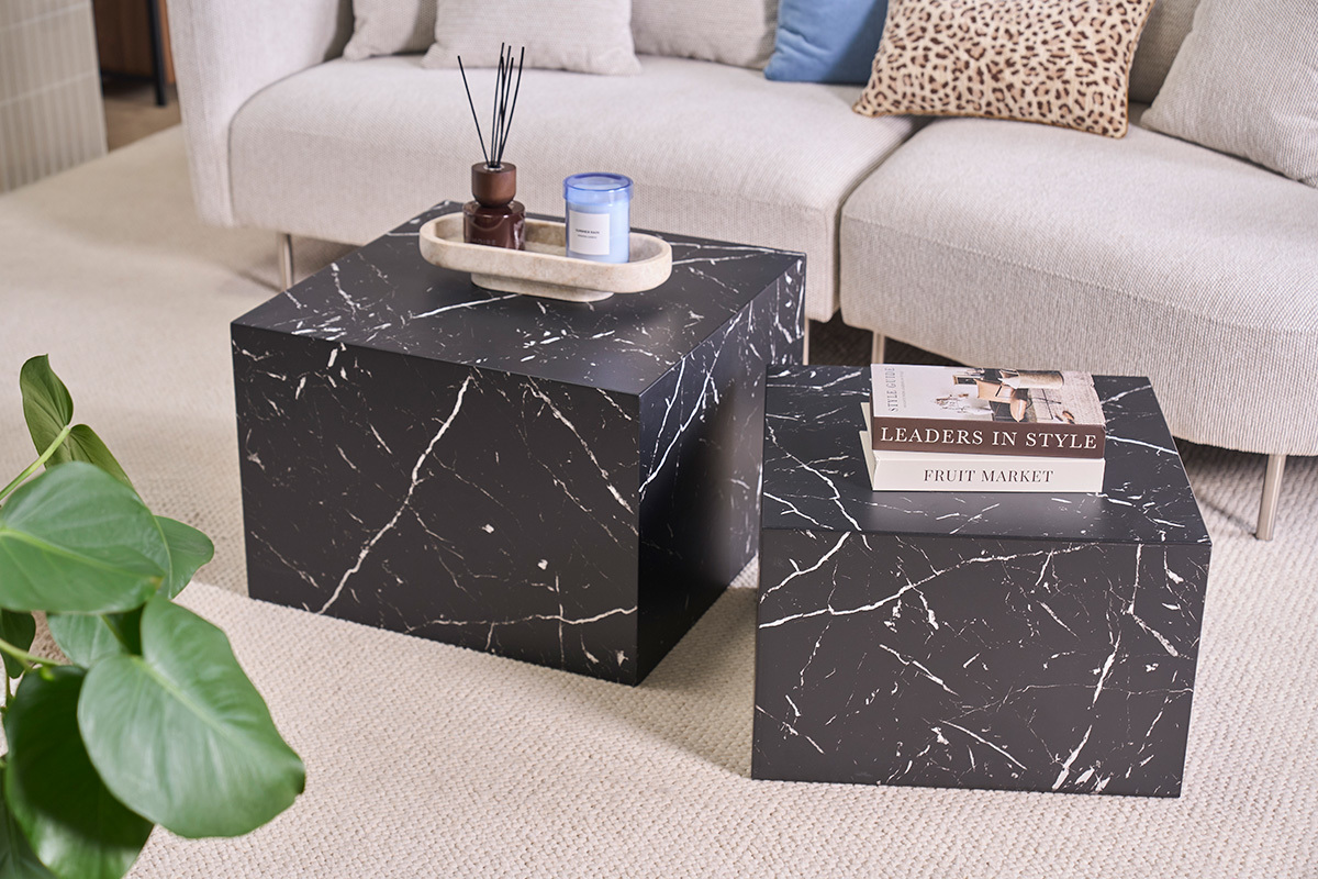 Set di 2 tavolini da caff� impilabili design effetto marmo nero, vista frontale, in un soggiorno.
