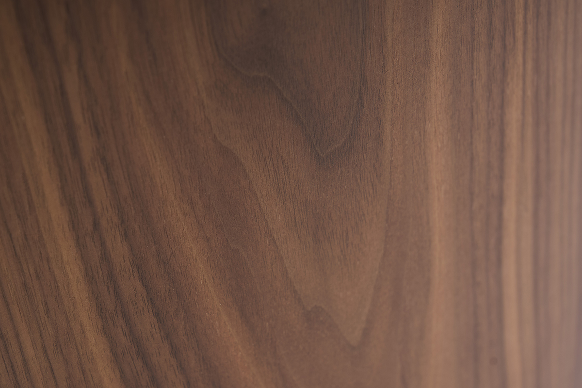 Primo piano della venatura del legno scuro noce del tavolino basso di design ovale ASSA.