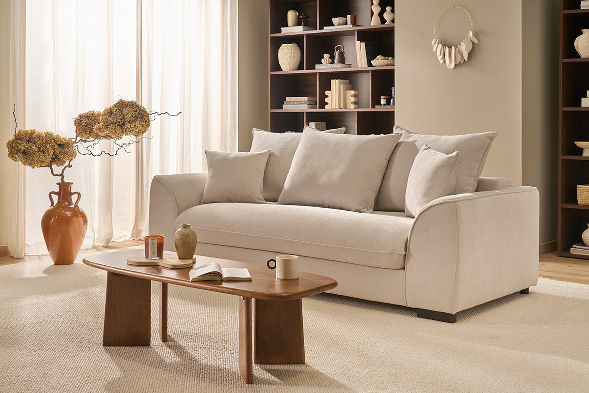 Tavolino basso rettangolare in legno massiccio di mango tinto, vista frontale con divano e accessori.
