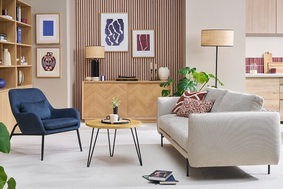 Tavolino basso rotondo in legno di mango e metallo, vista soggiorno con divano e poltrona.