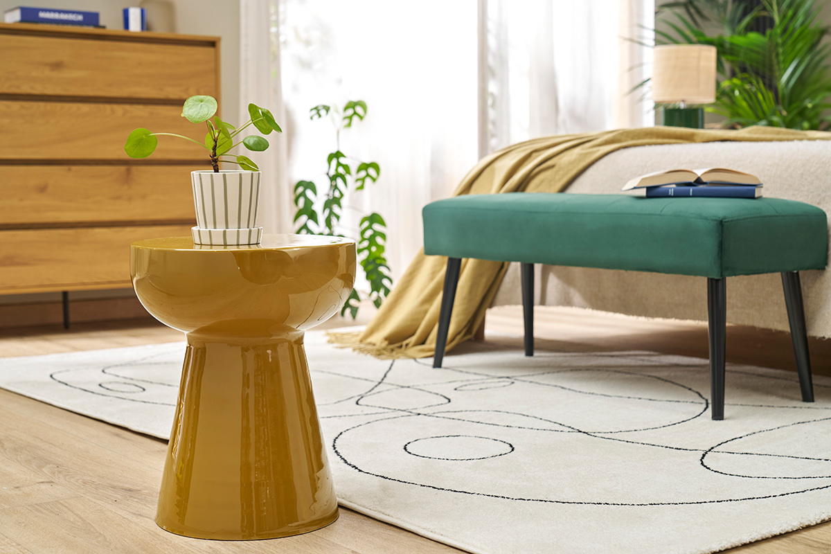 Tavolino rotondo in metallo smaltato bronzo con pianta vista frontale in una camera.