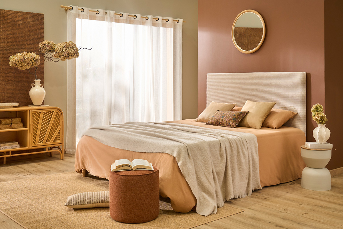 Camera con tavolino rotondo YOYO in metallo e legno vicino a un letto.