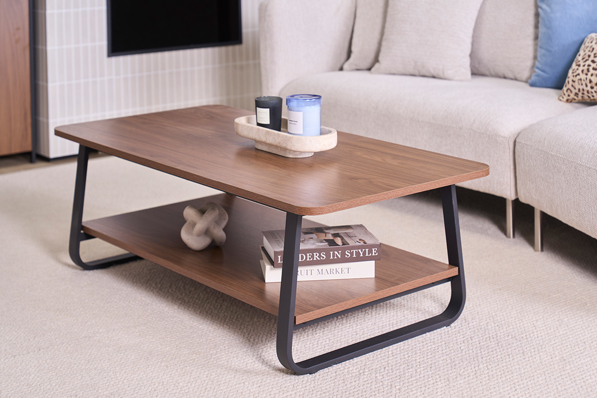 Tavolino basso rettangolare in legno di noce e metallo, vista frontale con oggetti decorativi.