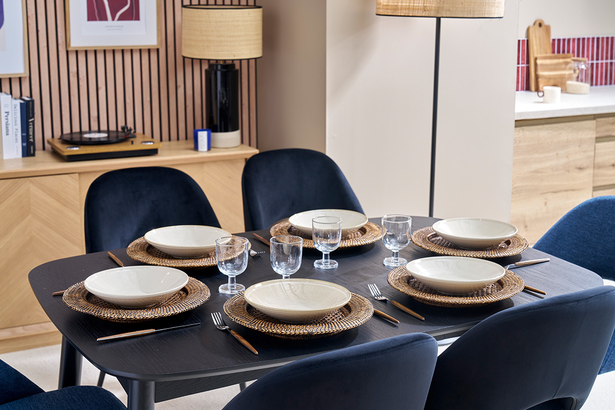 Tavolo da pranzo nero NORDECO apparecchiato con piatti e bicchieri, vista dall'alto.